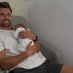 Henry Slade holding his baby