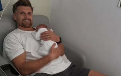 Henry Slade holding his baby