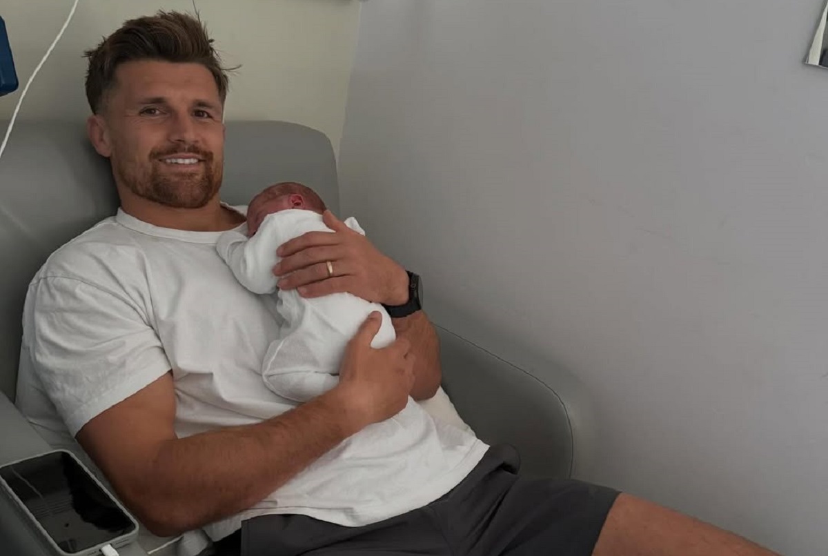 Henry Slade holding his baby